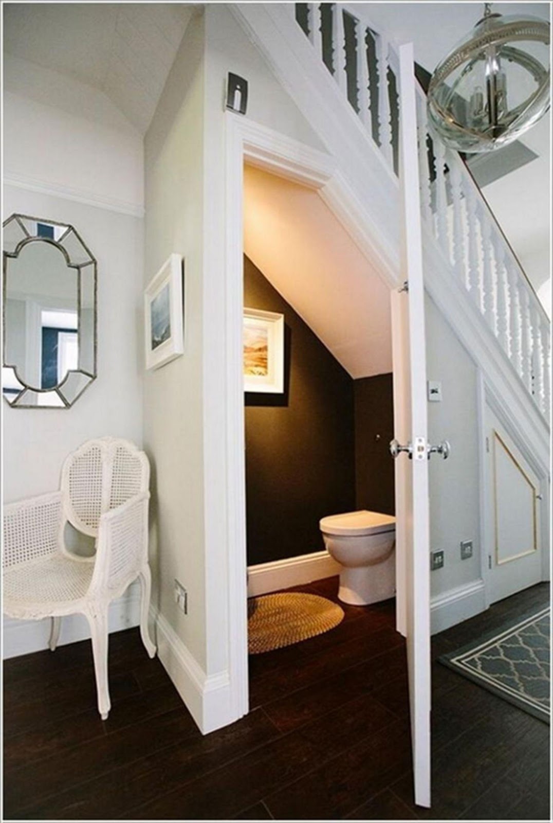 Trang trí phía ngoài nhà vệ sinh dưới gầm cầu thang bằng cách thiết kế thêm gương, tranh treo tường, kệ, giá cây… 